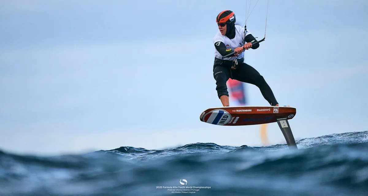 Kitefoiler in actie met kite boven het water
